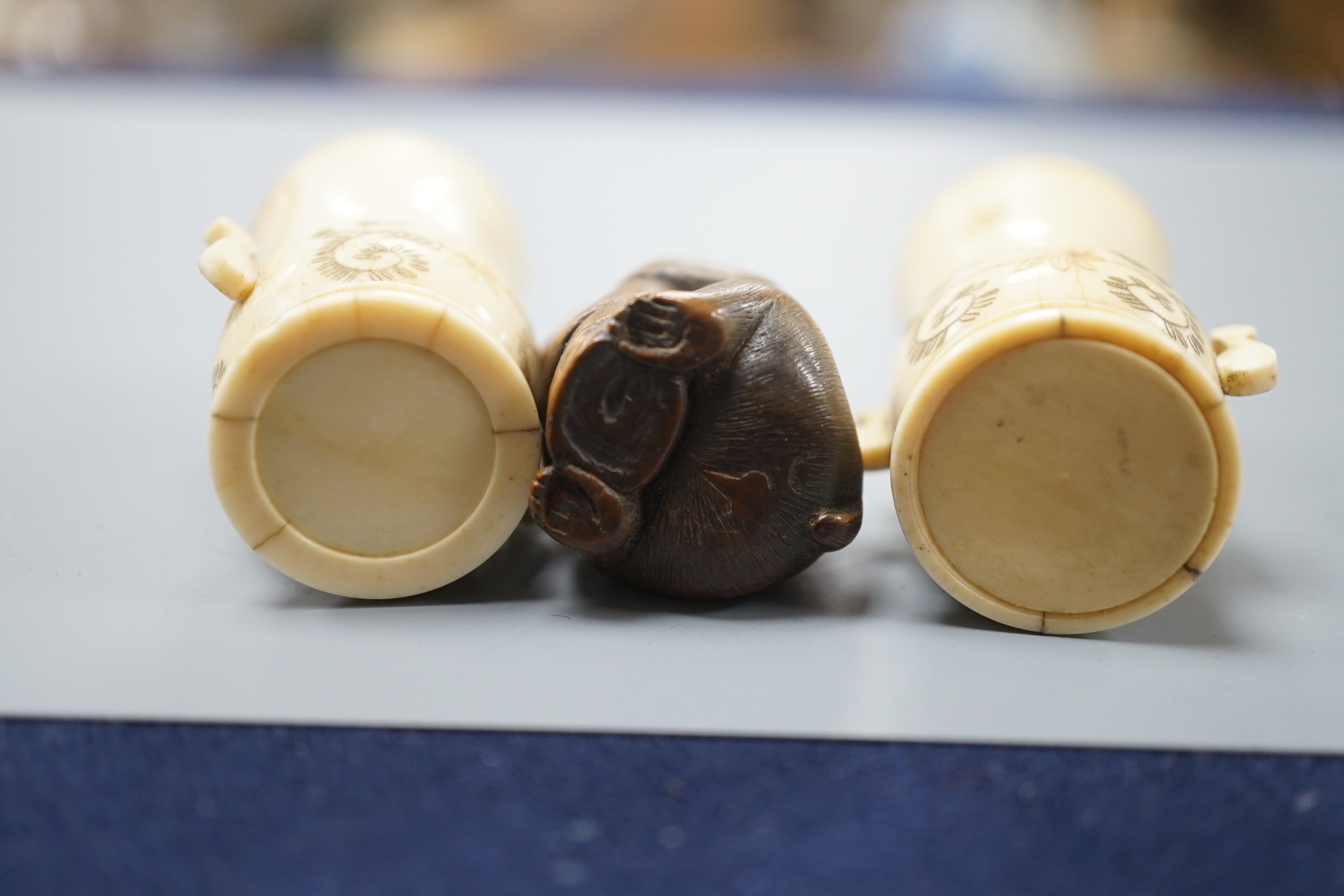 A pair of early 20th century Japanese miniature ivory vases, 5.3 cm, engraved with a lady and a wood netsuke in the form of a monkey holding a bamboo shoot (3)